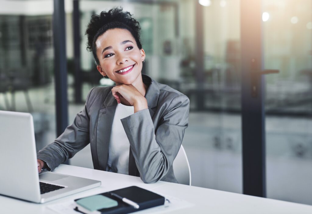 A young professional with a laptop thinking about career planning.