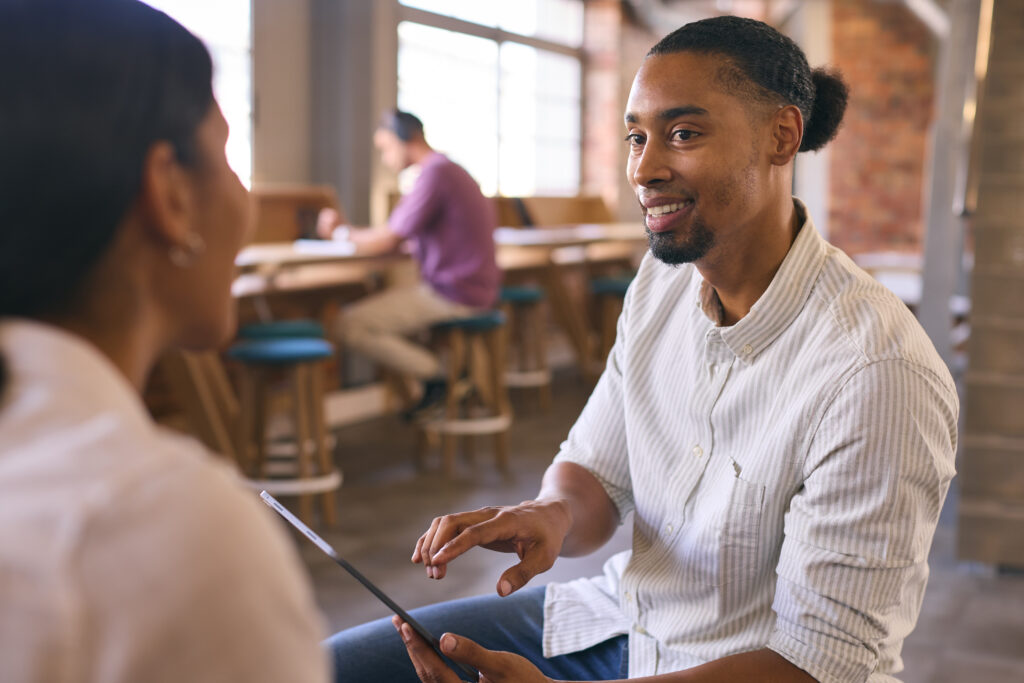 A male sales professional interviewing a customer about her needs.